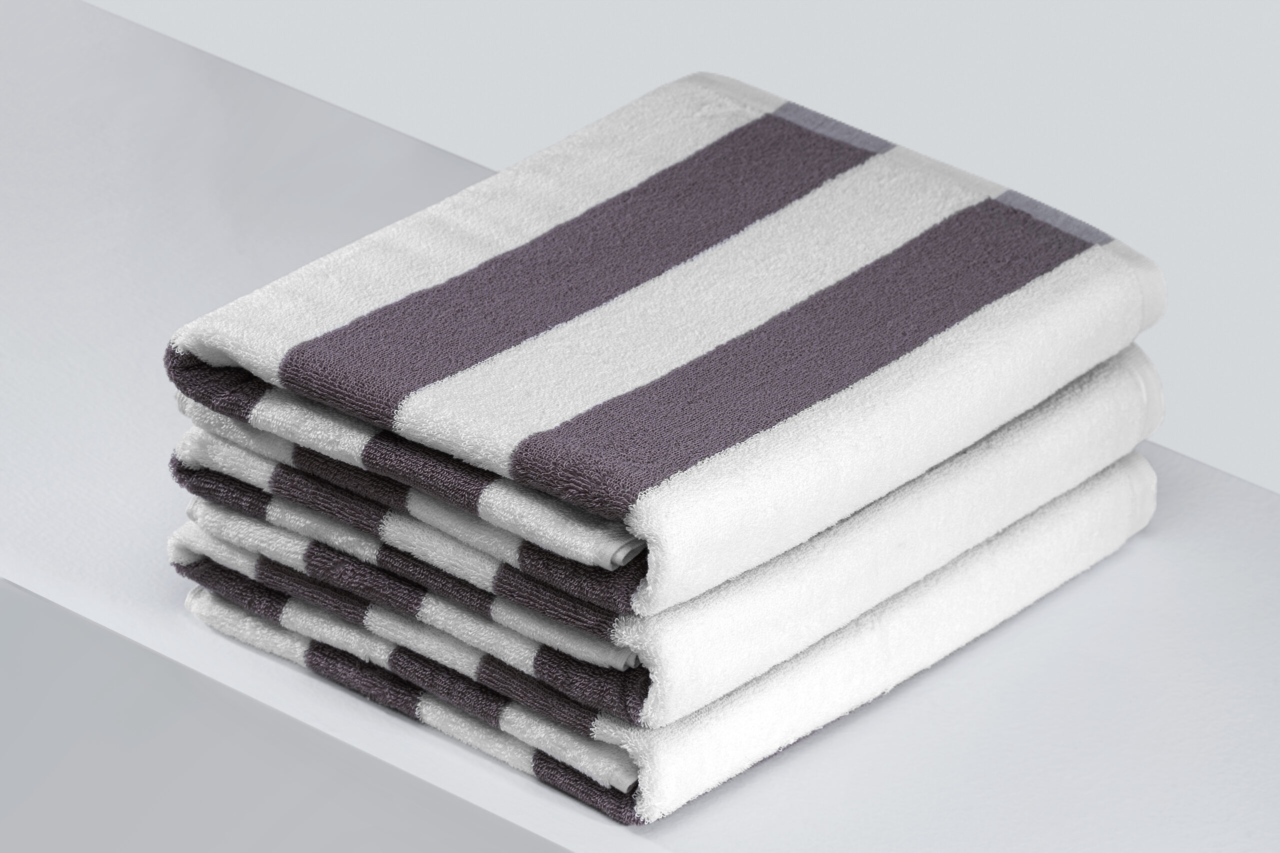 Stack of dark grey and white striped resort pool towels.