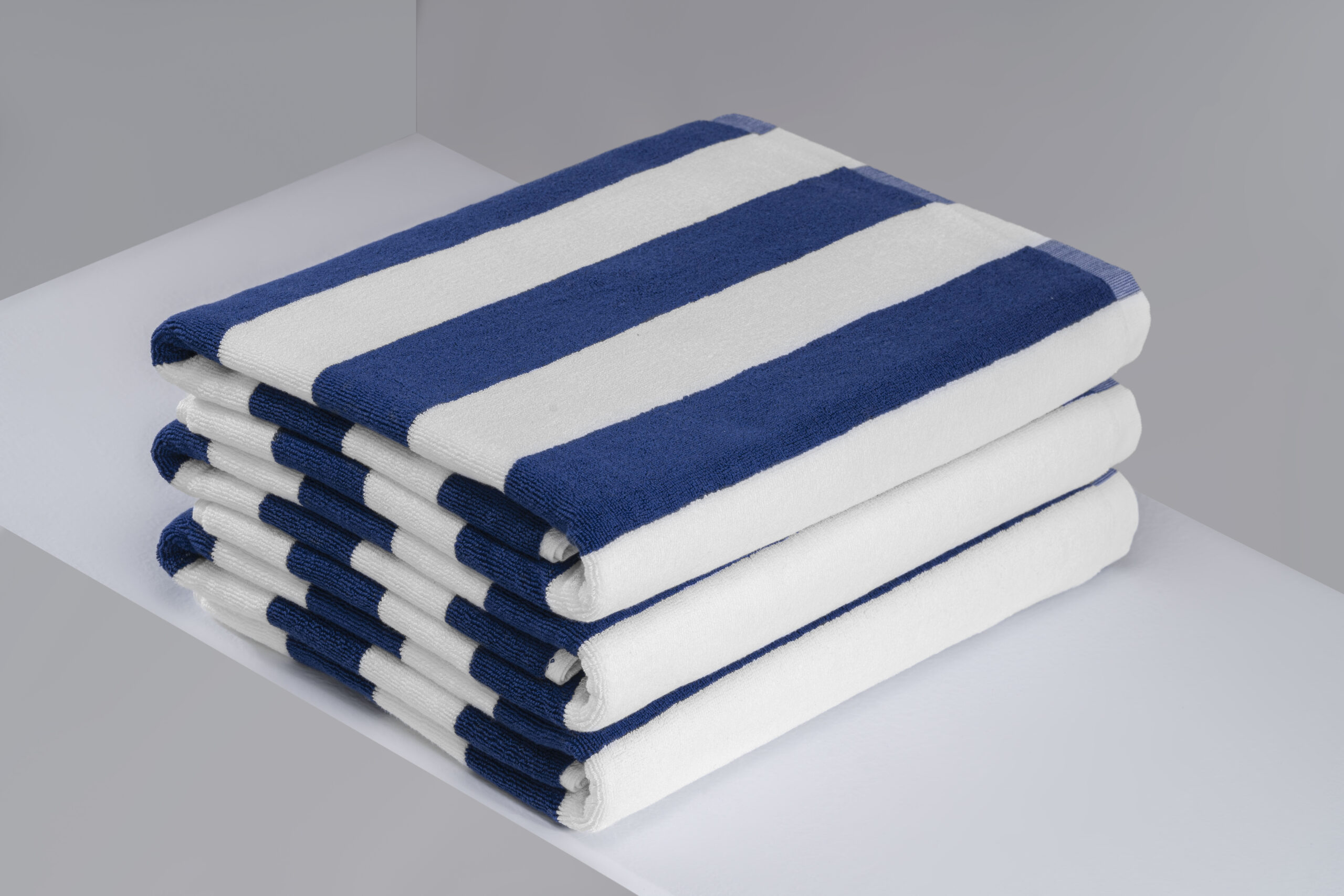 Stack of navy blue and white striped commercial pool towels.