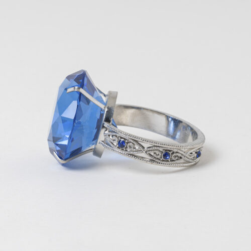 Galaxy vintage royal sapphire crystal ring napkin holder with silver filigree band on a clean white background.