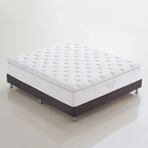 White tufted hotel mattress paired with a dark upholstered bed base and metal support legs.
