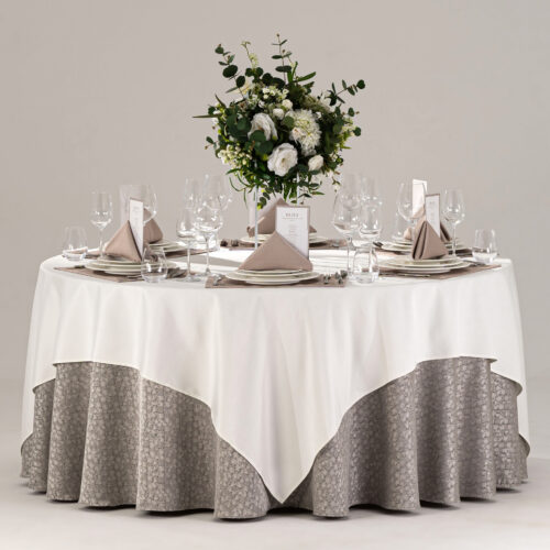 Product collage of a hotel round banquet table styled with white square overlay, grey textured skirt, taupe placemats, and gold cutlery.