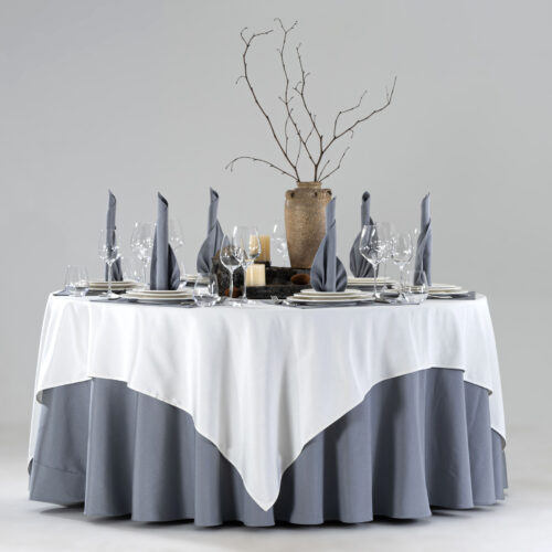 Product collage of a hotel round banquet table styled with white square overlay, slate blue skirt, embroidered placemats, and blue floral centerpiece.