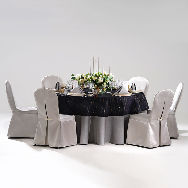 Gallery showing hotel banquet table setting details including silver jacquard chair covers, dark tablecloth, grey napkins, glass stemware, and candelabra.